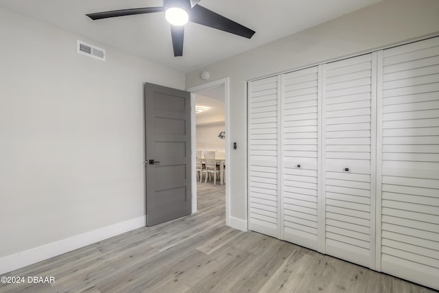 unfurnished bedroom with a ceiling fan, visible vents, baseboards, a closet, and light wood-type flooring