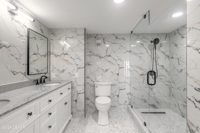 full bathroom with double vanity, a marble finish shower, toilet, stone wall, and a sink