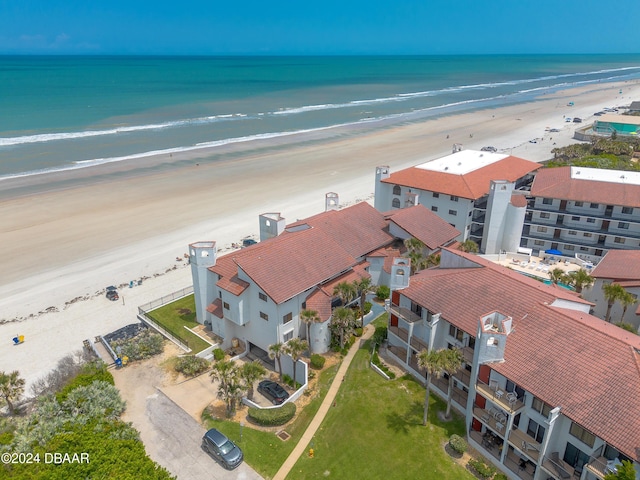 birds eye view of property with a water view and a beach view