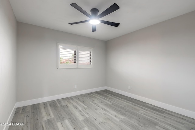 unfurnished room with light wood finished floors, baseboards, and a ceiling fan