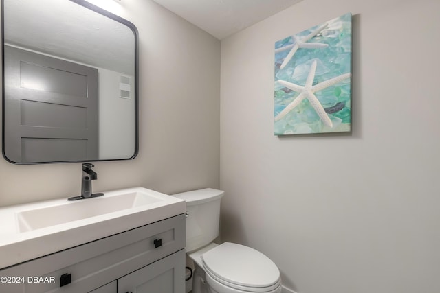 half bathroom with vanity and toilet