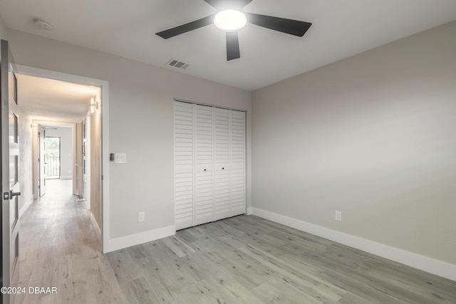 unfurnished bedroom with light wood finished floors, a closet, visible vents, and baseboards