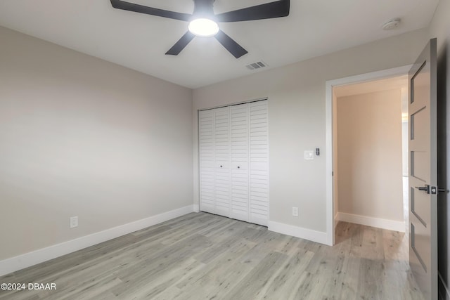 unfurnished bedroom featuring a closet, visible vents, light wood-style flooring, and baseboards