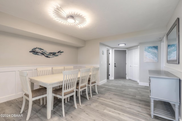 dining space featuring light wood-style floors and wainscoting