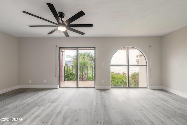 spare room featuring light wood-style flooring, baseboards, and ceiling fan