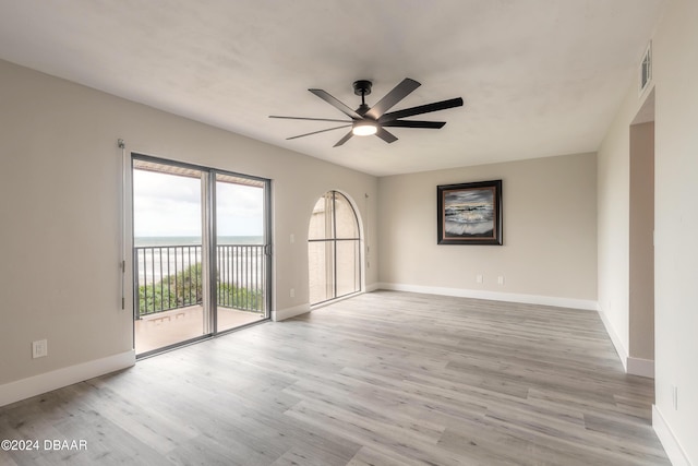 empty room featuring light wood finished floors, visible vents, baseboards, and a ceiling fan