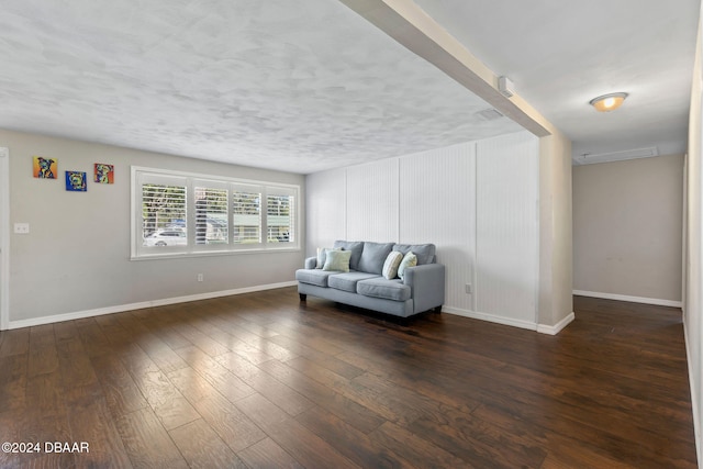 living room with dark wood-type flooring and a textured ceiling