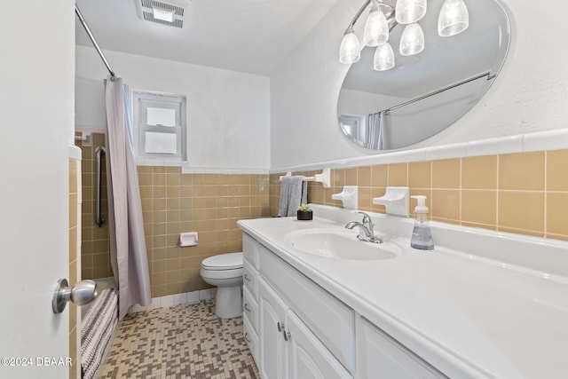 full bathroom with vanity, toilet, shower / bath combo with shower curtain, and tile walls