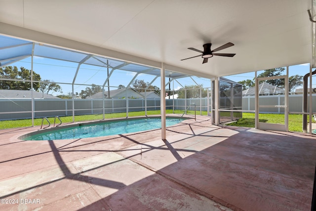 view of swimming pool featuring a lawn, ceiling fan, a patio area, and a lanai