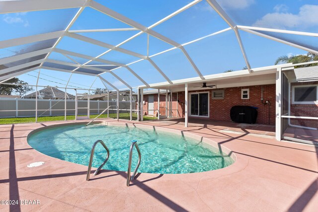 view of pool featuring a patio area, ceiling fan, and a lanai