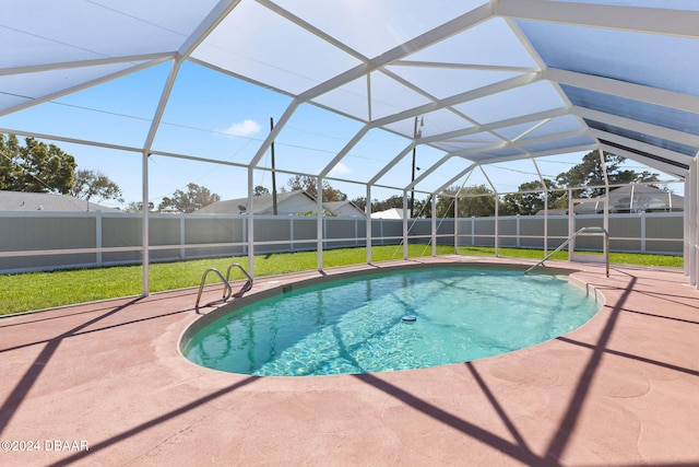 view of swimming pool with a yard, a patio, and a lanai