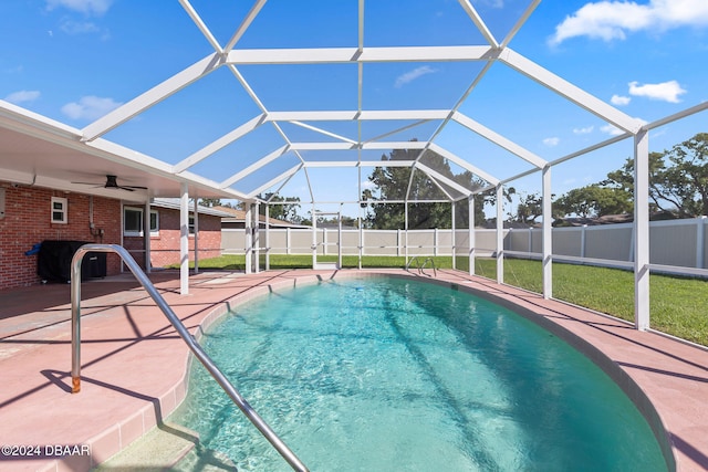 view of swimming pool with ceiling fan, a patio area, and a lanai