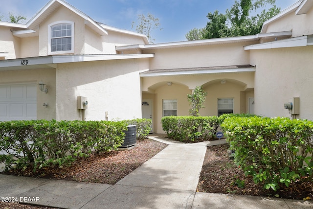 doorway to property with a garage and central air condition unit