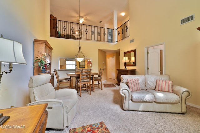 living room with light carpet, a high ceiling, and ceiling fan