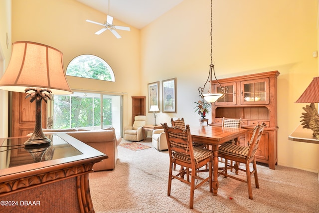 dining room featuring light colored carpet, high vaulted ceiling, and ceiling fan