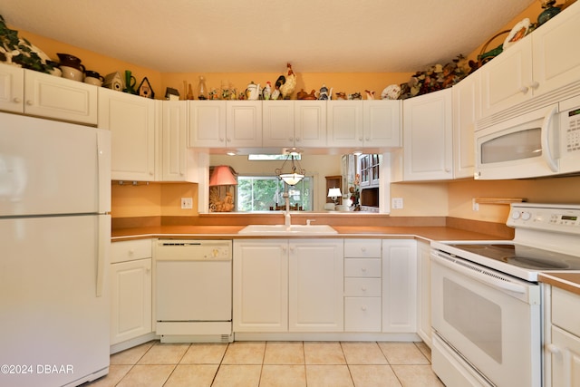 kitchen featuring white cabinets, white appliances, sink, and light tile patterned floors