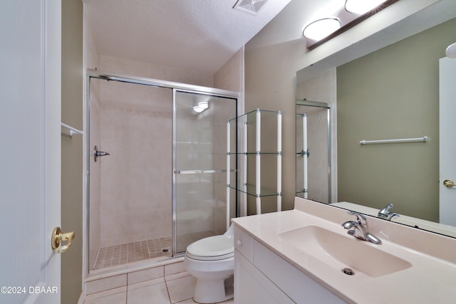 bathroom with tile patterned flooring, vanity, toilet, and a shower with shower door