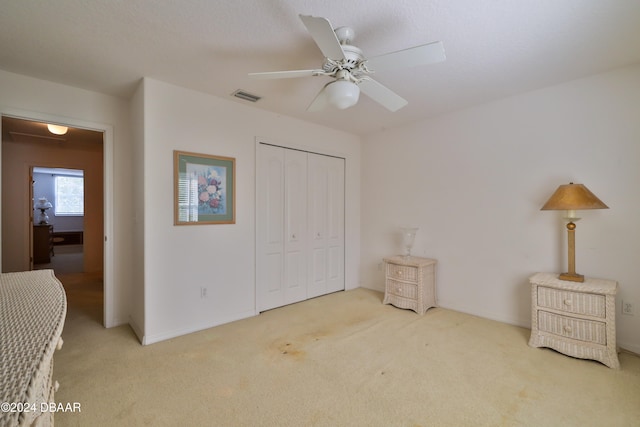 carpeted bedroom featuring a closet and ceiling fan