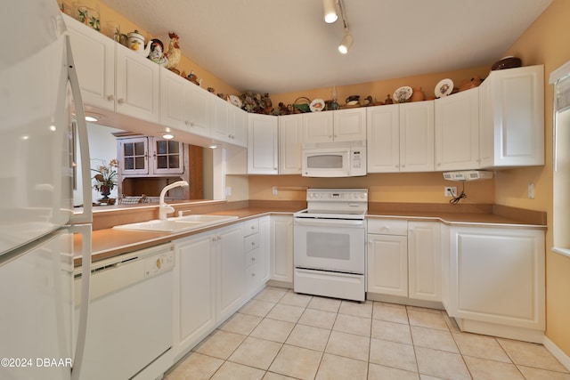 kitchen featuring white cabinets, white appliances, light tile patterned flooring, and sink