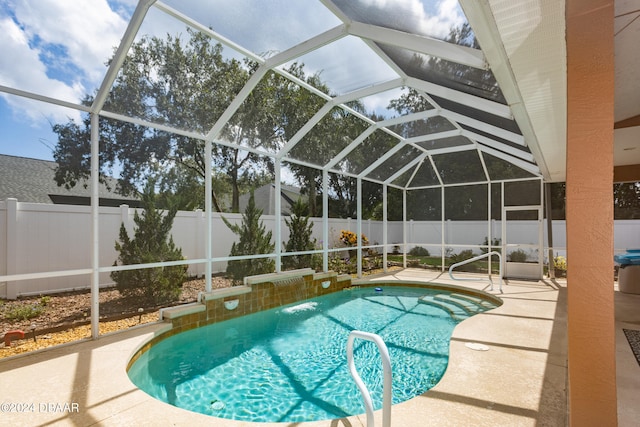 view of pool featuring pool water feature, a patio area, and a lanai