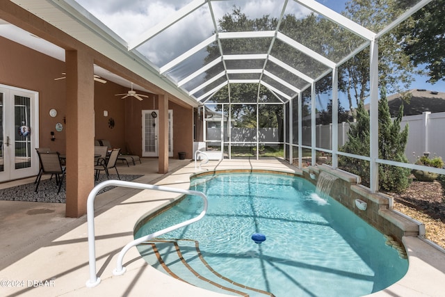 view of swimming pool with pool water feature, glass enclosure, ceiling fan, and a patio area