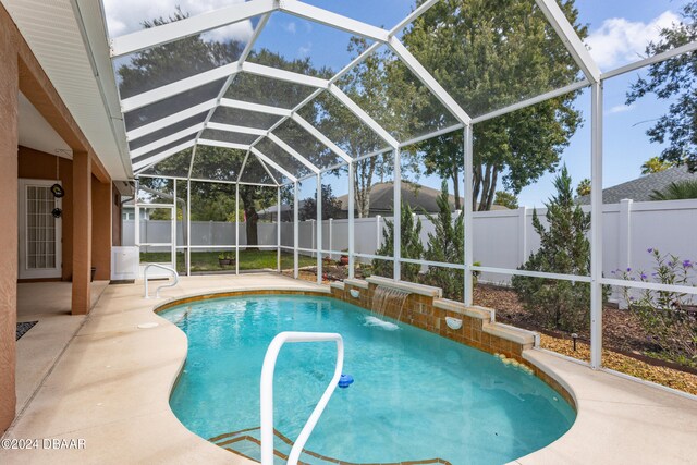 view of pool featuring pool water feature, glass enclosure, and a patio