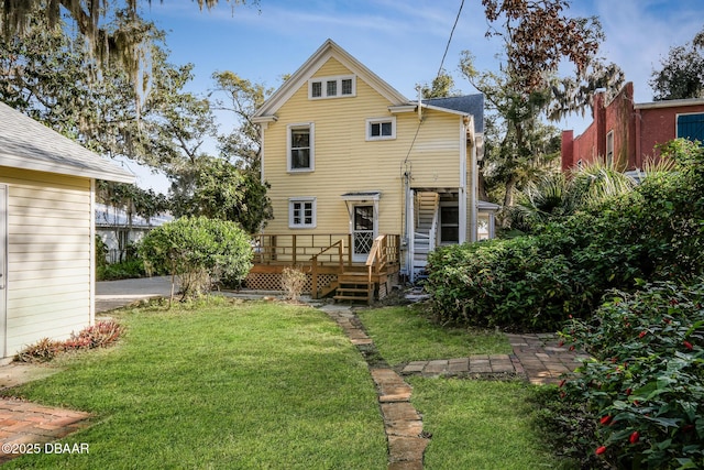 rear view of property featuring a deck and a lawn