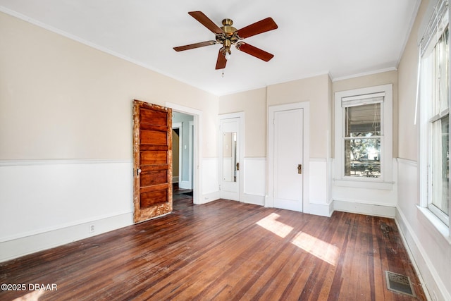 unfurnished bedroom featuring dark wood-type flooring, ornamental molding, and ceiling fan