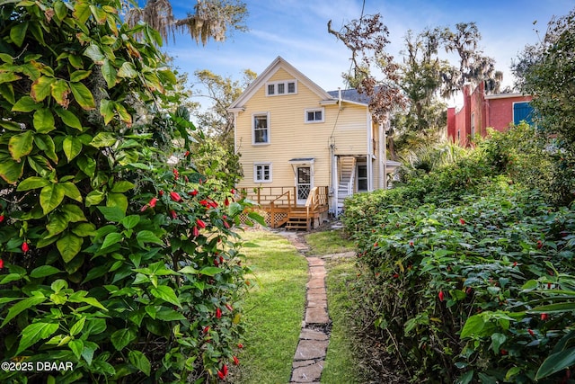 rear view of house with a yard and a deck