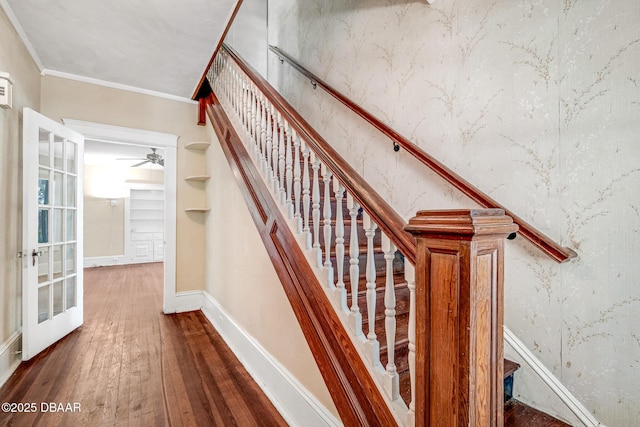 stairs with crown molding, hardwood / wood-style flooring, and ceiling fan