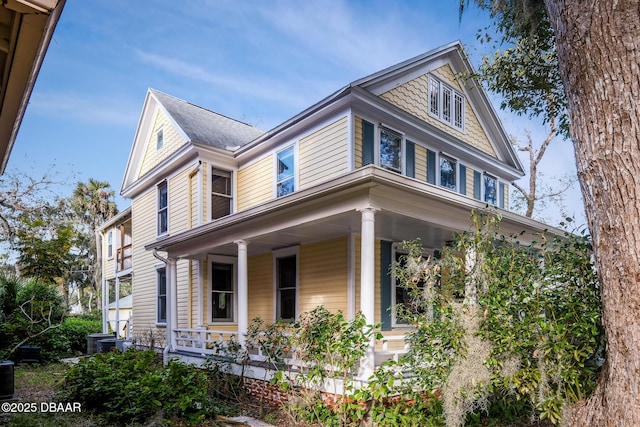 view of side of property featuring covered porch