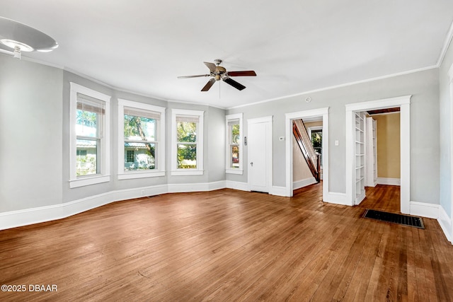 unfurnished living room featuring crown molding, wood-type flooring, built in features, and ceiling fan