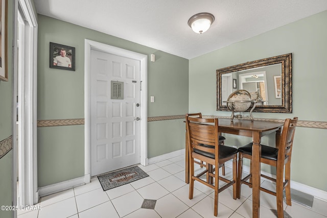 dining room featuring light tile patterned floors and a textured ceiling