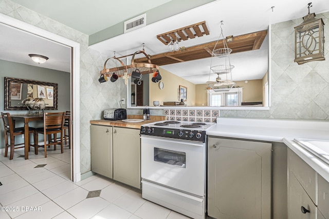 kitchen featuring gray cabinetry, light tile patterned floors, white electric stove, and tile walls