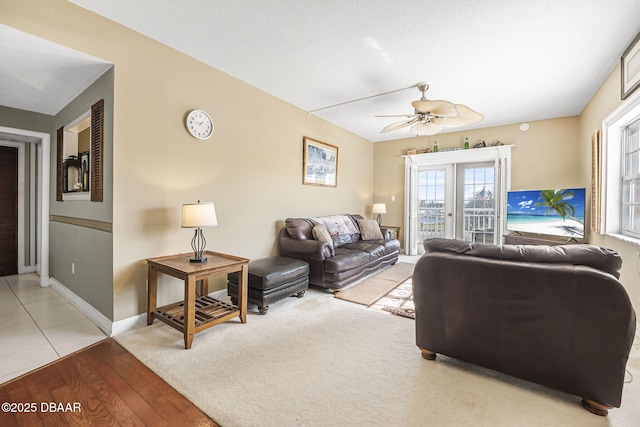 living room featuring french doors, a textured ceiling, ceiling fan, and light hardwood / wood-style flooring