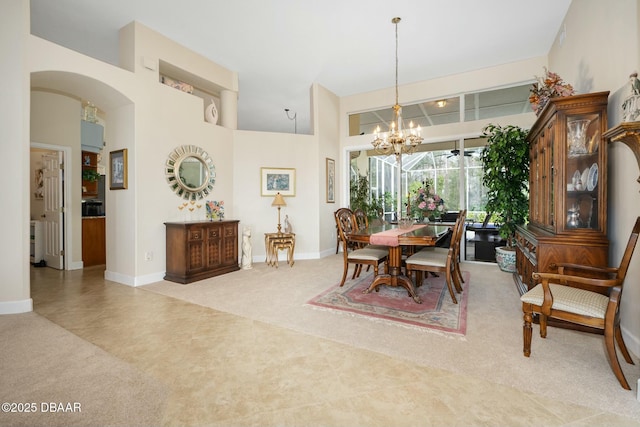 dining space featuring a high ceiling, carpet, and an inviting chandelier