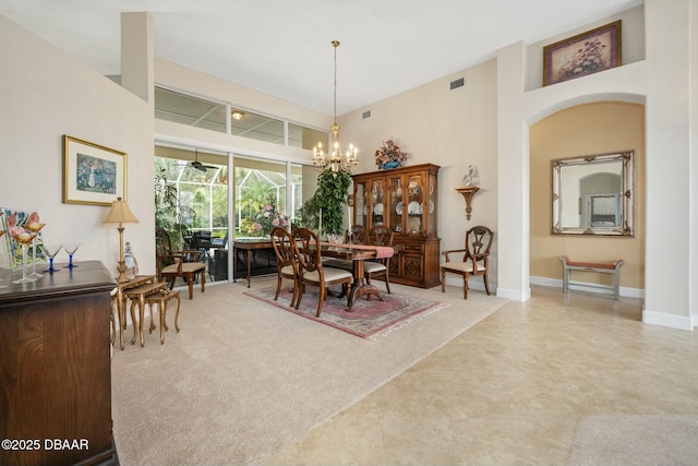 dining room with a towering ceiling and a chandelier