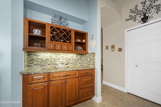 bar featuring light stone counters and decorative backsplash