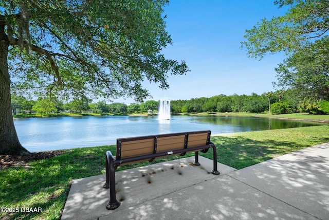 view of community with a water view and a lawn