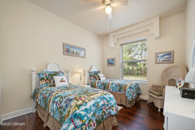 bedroom with ceiling fan, dark hardwood / wood-style flooring, and a textured ceiling