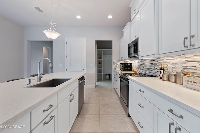 kitchen with stainless steel appliances, sink, light stone countertops, white cabinets, and pendant lighting