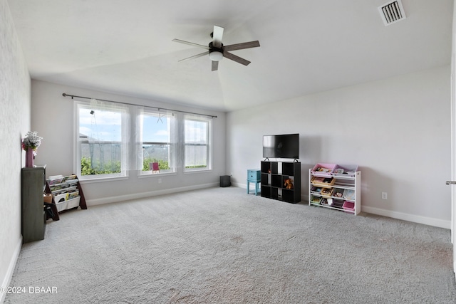 interior space featuring vaulted ceiling, light carpet, and ceiling fan