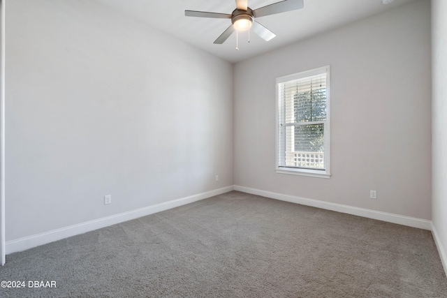 empty room featuring ceiling fan and carpet