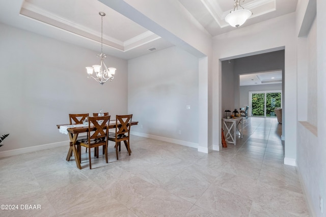 dining room featuring a chandelier and a raised ceiling