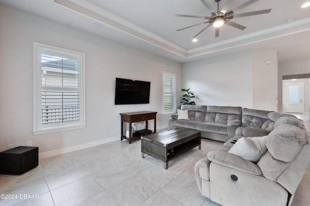 living room featuring light tile patterned flooring, ceiling fan, a healthy amount of sunlight, and a raised ceiling