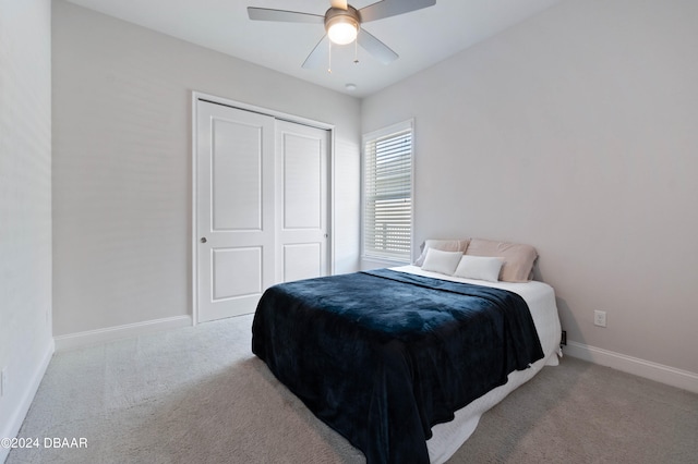 bedroom featuring a closet, light colored carpet, and ceiling fan