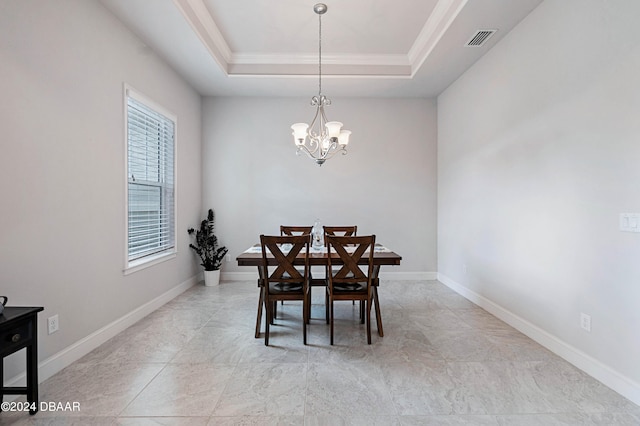 dining area with a notable chandelier, crown molding, and a raised ceiling