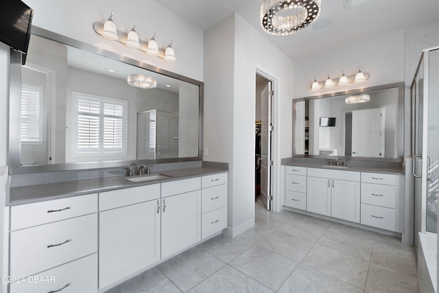 bathroom with walk in shower, vanity, and an inviting chandelier