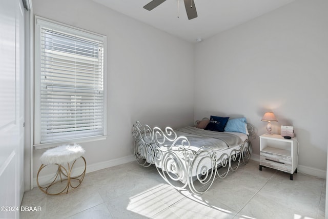 bedroom featuring ceiling fan, multiple windows, and light tile patterned floors