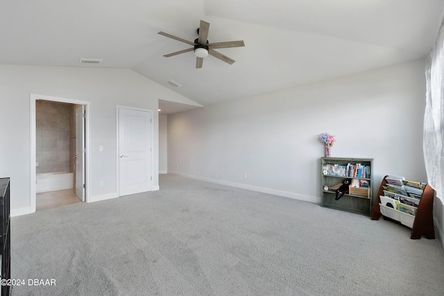 bedroom featuring ceiling fan, ensuite bath, light carpet, and lofted ceiling